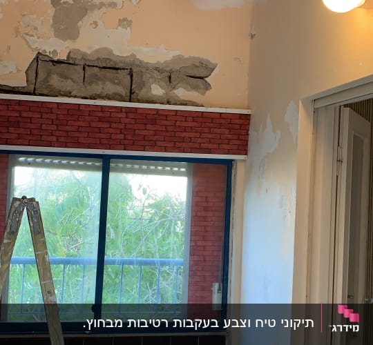 קיר מתקלף עם סולם וחלון גדול